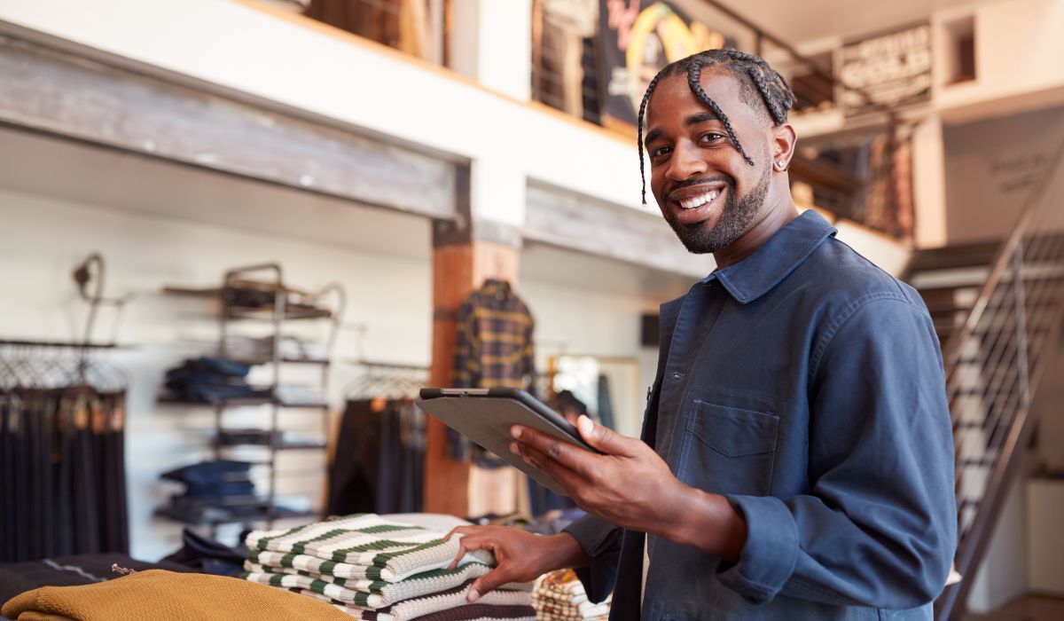 male business owner holding tablet and smiling