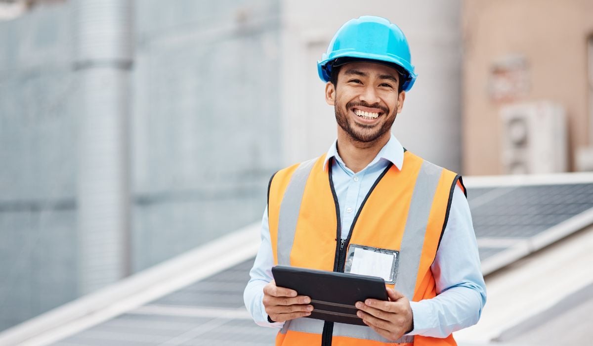 construction worker smiling and holding tablet