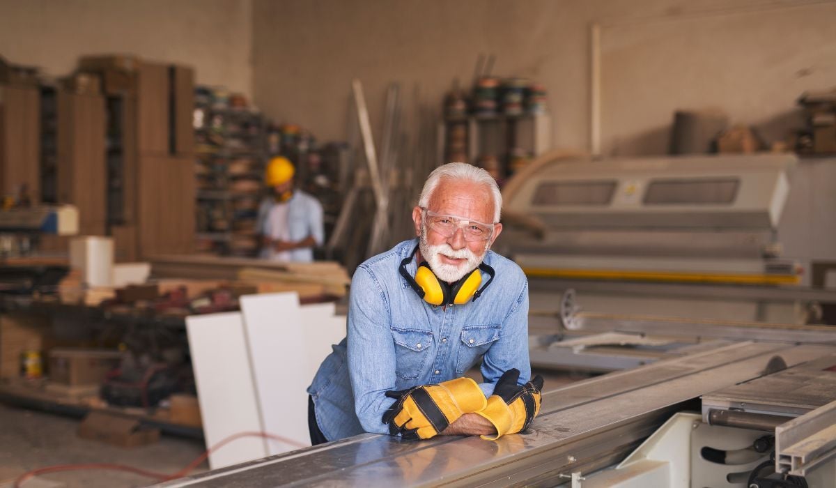 construction man leaning over bench and smiling