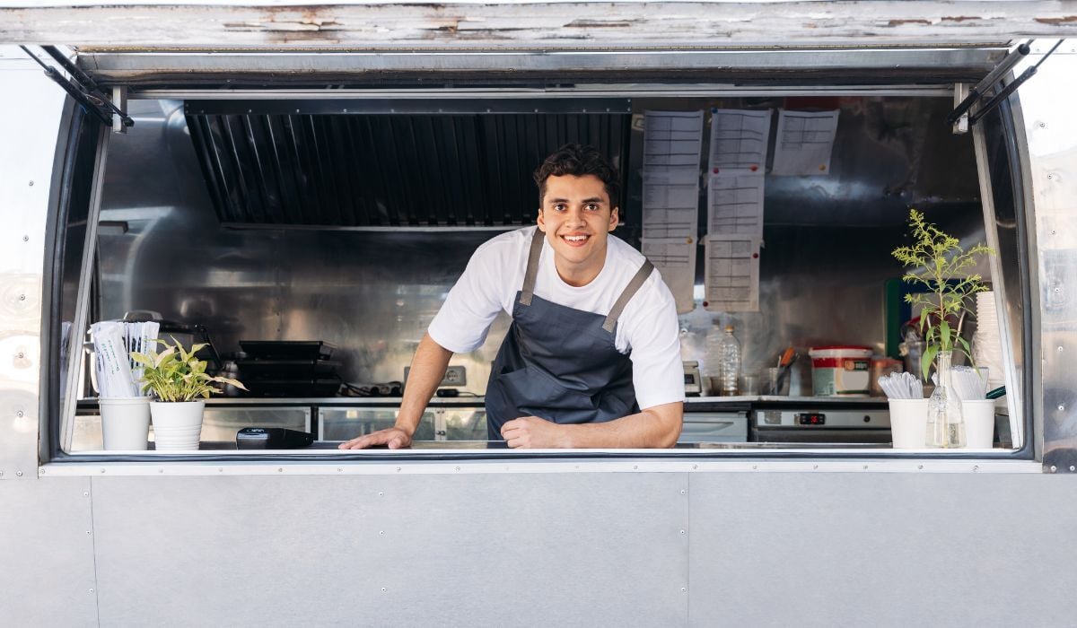 smiling man leaning out of food truck