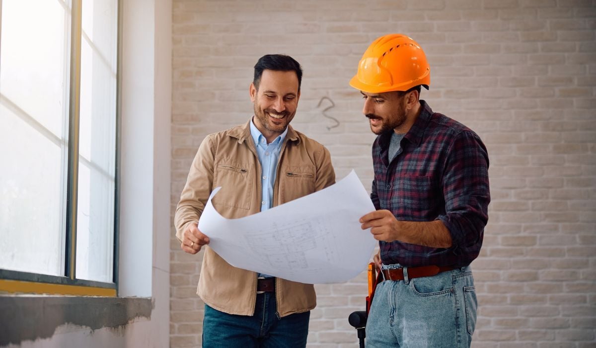 two construction workers looking at blueprints together