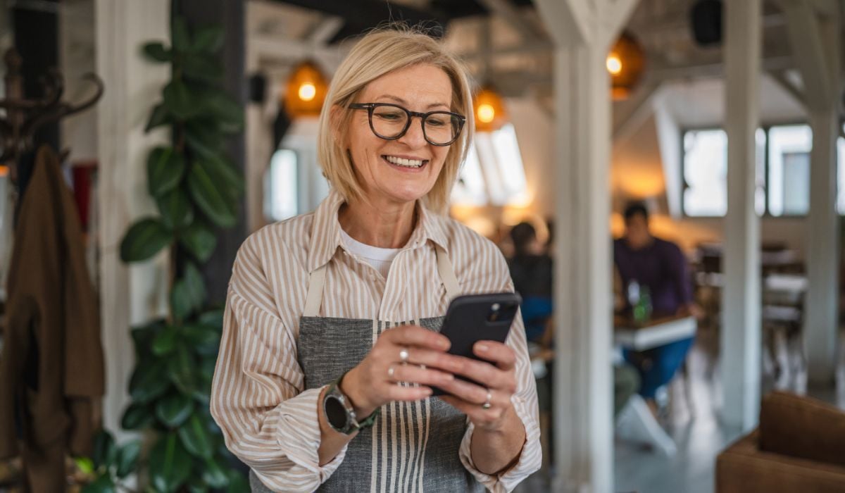 happy older woman looking at cell phone